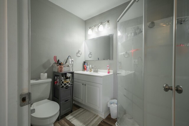 full bathroom with vanity, wood finished floors, a shower stall, and toilet