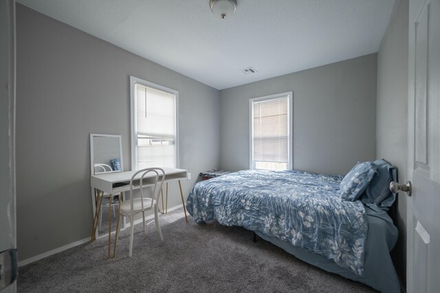 bedroom with visible vents, multiple windows, baseboards, and carpet
