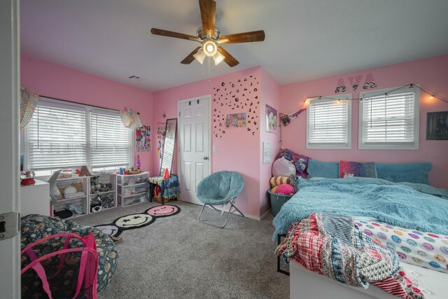 carpeted bedroom featuring a ceiling fan and visible vents