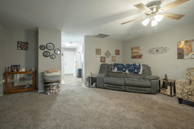 living area with carpet flooring, a ceiling fan, and visible vents