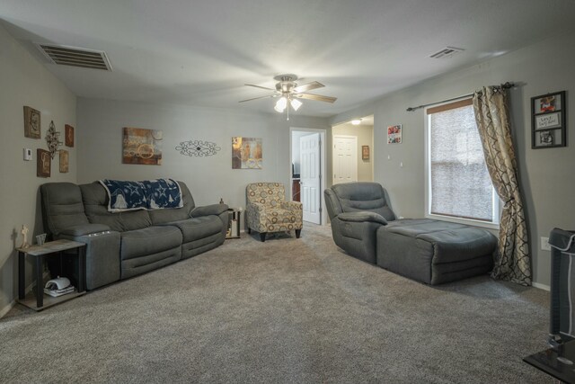 living area featuring visible vents, a ceiling fan, and carpet floors