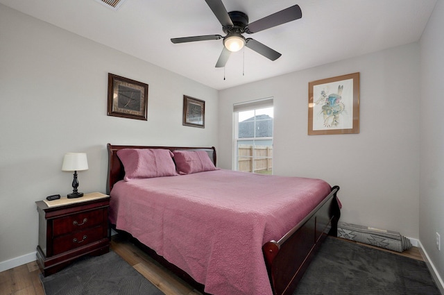 bedroom featuring dark wood-style floors, ceiling fan, and baseboards