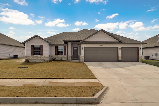 view of front of house featuring stone siding, central AC, an attached garage, and driveway