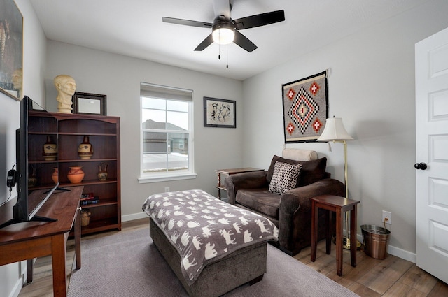 sitting room with baseboards, a ceiling fan, and wood finished floors