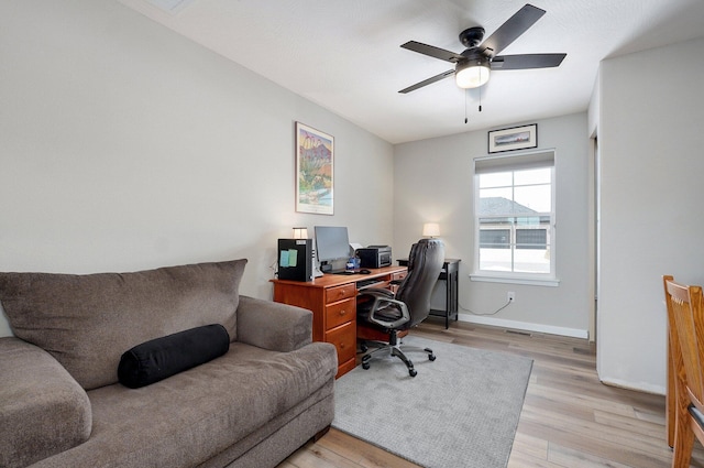 home office with ceiling fan, light wood-style flooring, and baseboards