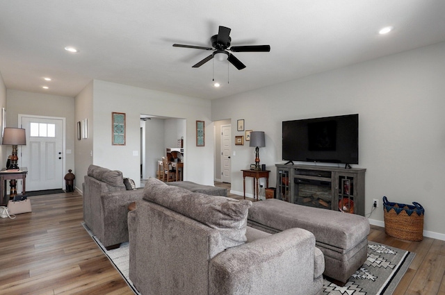 living area featuring a ceiling fan, recessed lighting, baseboards, and wood finished floors