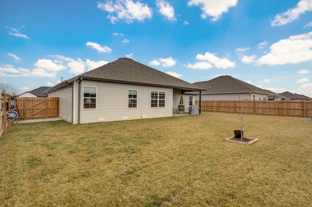 back of house featuring a lawn and a fenced backyard