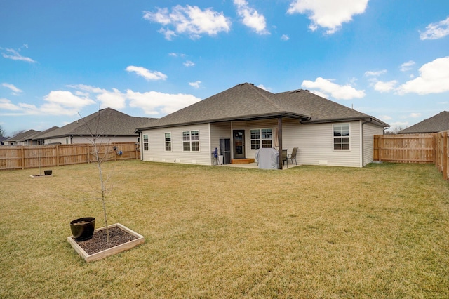 back of house with a patio, a lawn, a fenced backyard, and roof with shingles