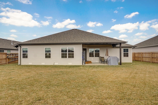 back of house with a fenced backyard, a shingled roof, and a lawn