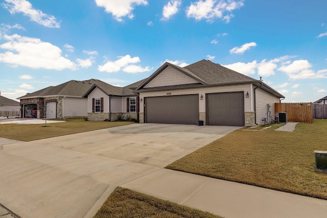 ranch-style house featuring an attached garage, central AC, fence, stone siding, and a front yard