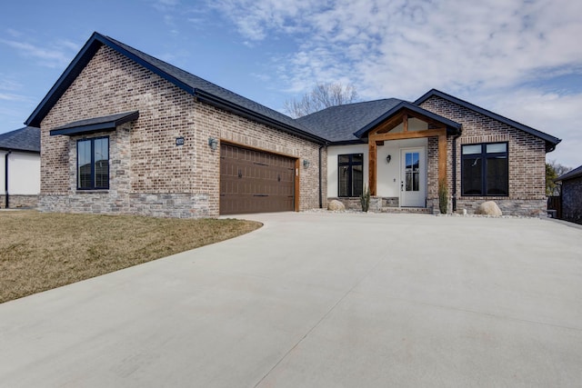 view of front of property with a garage, driveway, a front lawn, and brick siding