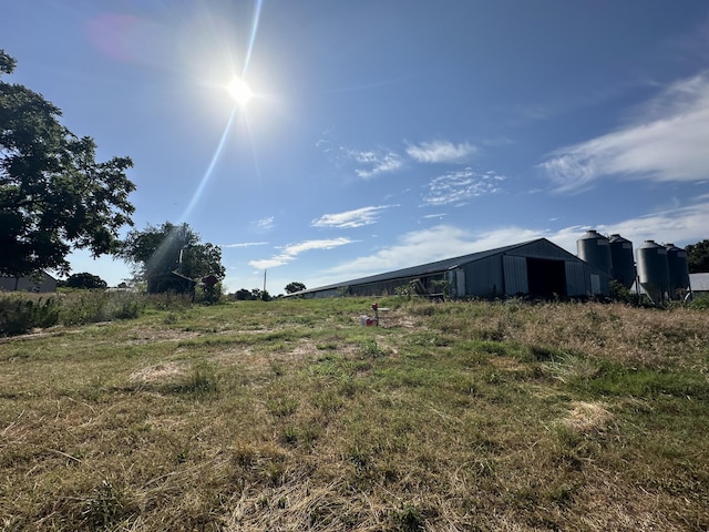 view of yard with an outbuilding, a rural view, and an outdoor structure