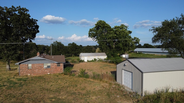 view of yard with a detached garage and an outdoor structure