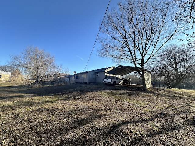 view of side of home with a carport and a yard