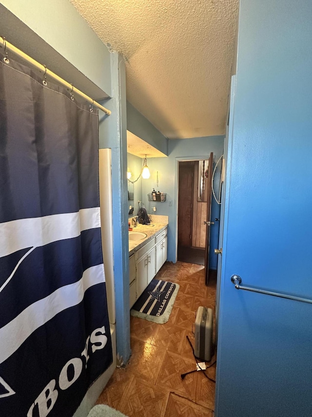 bathroom with a textured ceiling and vanity