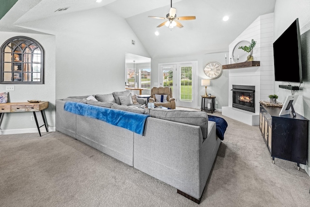 living area featuring visible vents, a ceiling fan, a tile fireplace, light colored carpet, and high vaulted ceiling