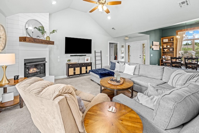 living room with light colored carpet, a fireplace, a ceiling fan, visible vents, and vaulted ceiling