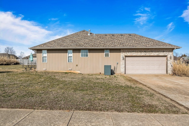 view of home's exterior with an attached garage, driveway, a yard, and a shingled roof