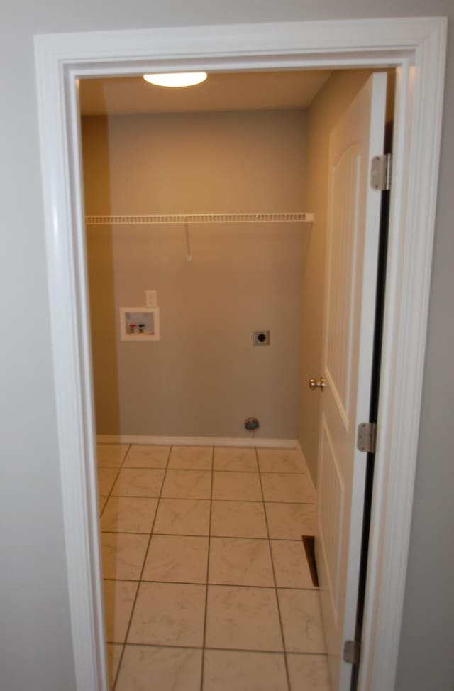 washroom with washer hookup, light tile patterned flooring, electric dryer hookup, laundry area, and baseboards