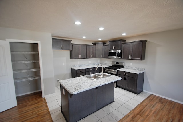 kitchen with appliances with stainless steel finishes, recessed lighting, a sink, and a center island with sink