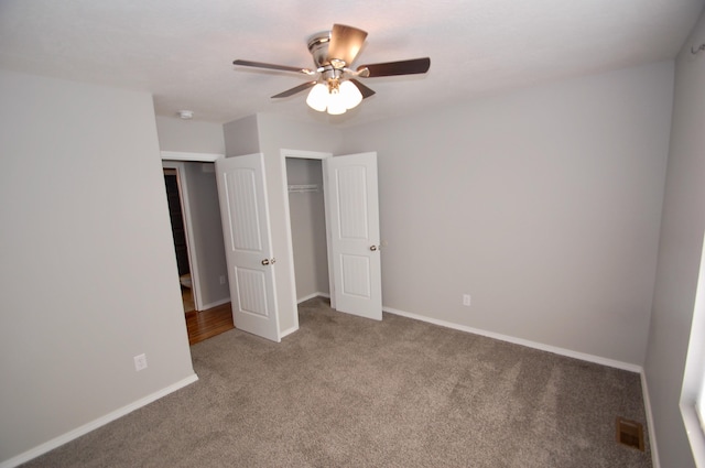 unfurnished bedroom featuring ceiling fan, carpet flooring, visible vents, baseboards, and a closet