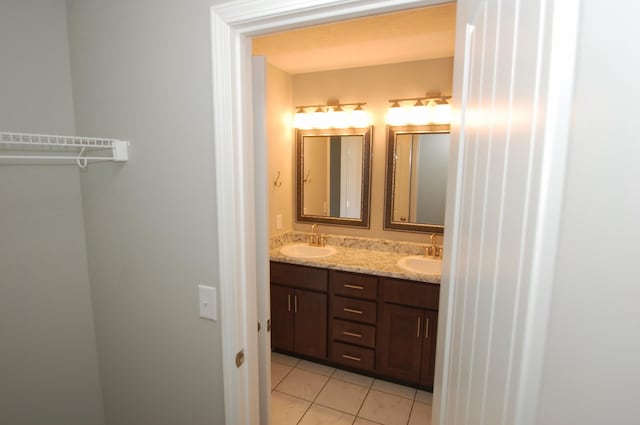 full bathroom featuring double vanity, tile patterned flooring, and a sink