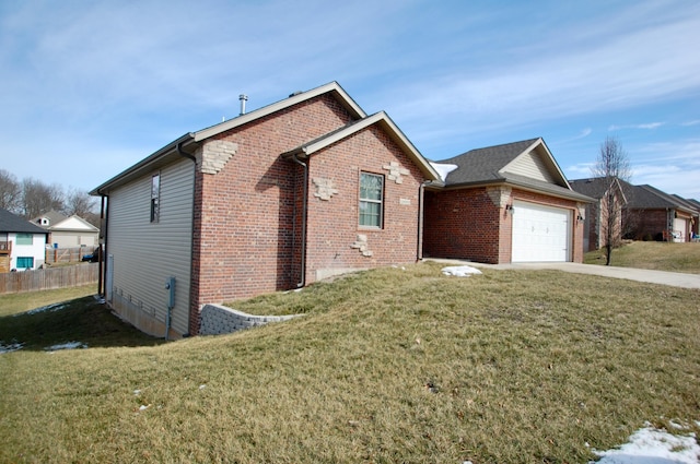 view of side of home featuring a garage, concrete driveway, fence, a yard, and brick siding