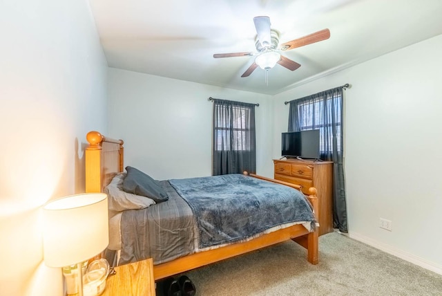 bedroom with light carpet, ceiling fan, and baseboards