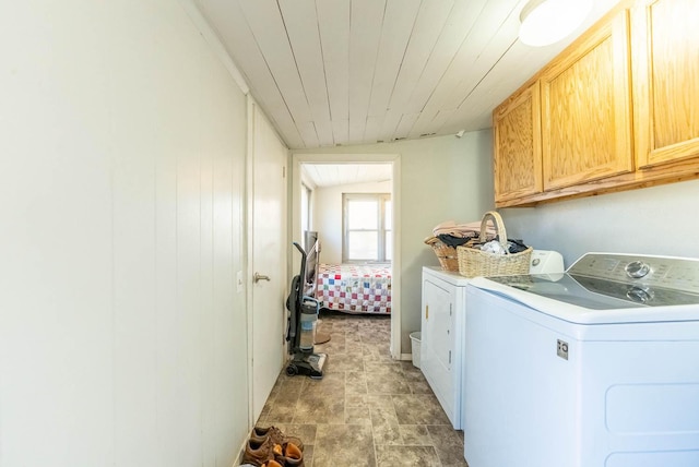 washroom with wooden ceiling, cabinet space, and separate washer and dryer