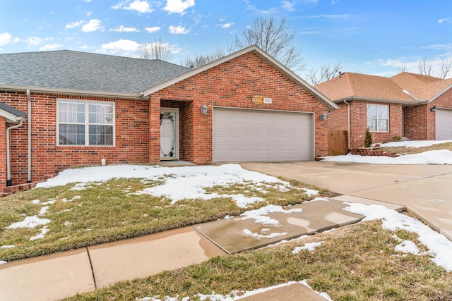 single story home featuring a shingled roof, concrete driveway, brick siding, and an attached garage