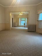 unfurnished room featuring a wealth of natural light, radiator heating unit, and crown molding