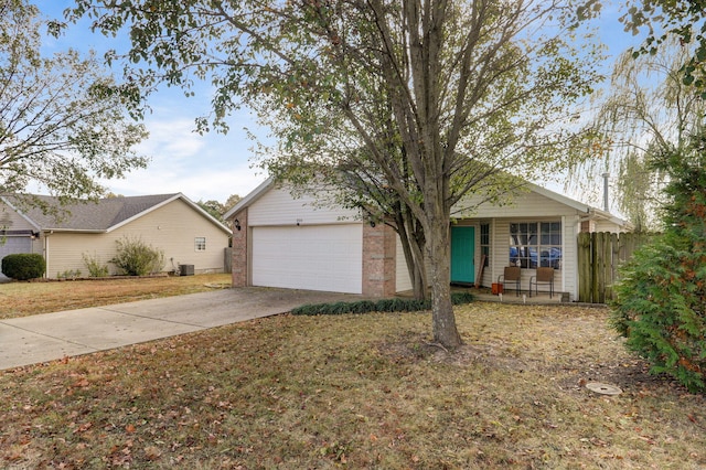 view of front of home featuring a garage, brick siding, fence, driveway, and a front lawn