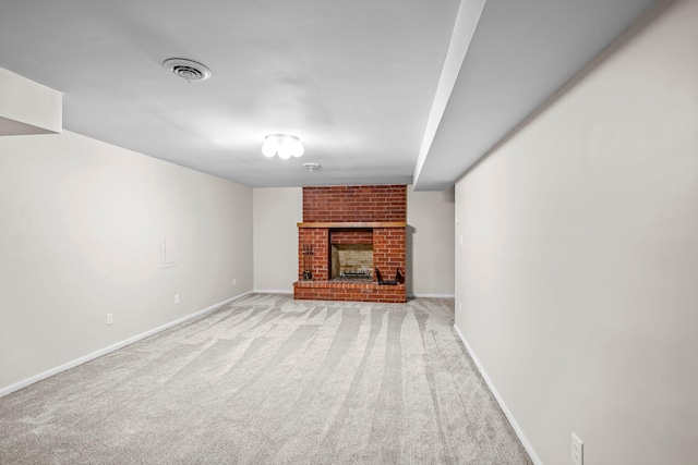 unfurnished living room with light carpet, a brick fireplace, visible vents, and baseboards