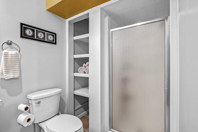 bathroom with a shower stall and toilet