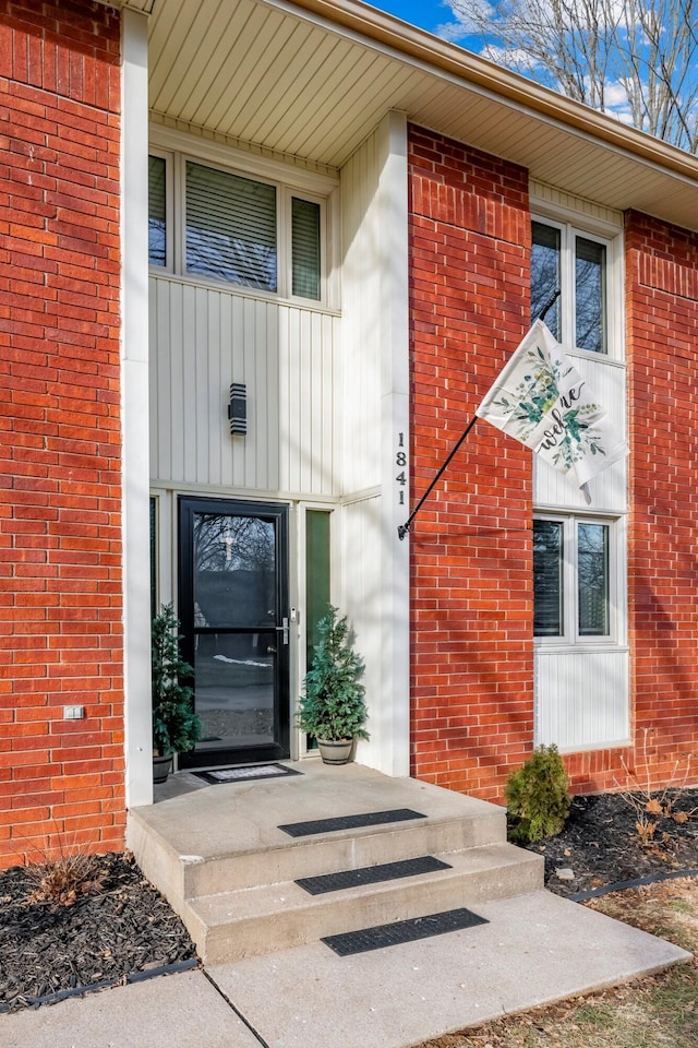 view of exterior entry featuring brick siding