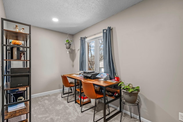 office with baseboards, a textured ceiling, and light colored carpet