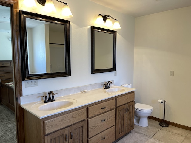 full bathroom featuring double vanity, tile patterned flooring, baseboards, and a sink