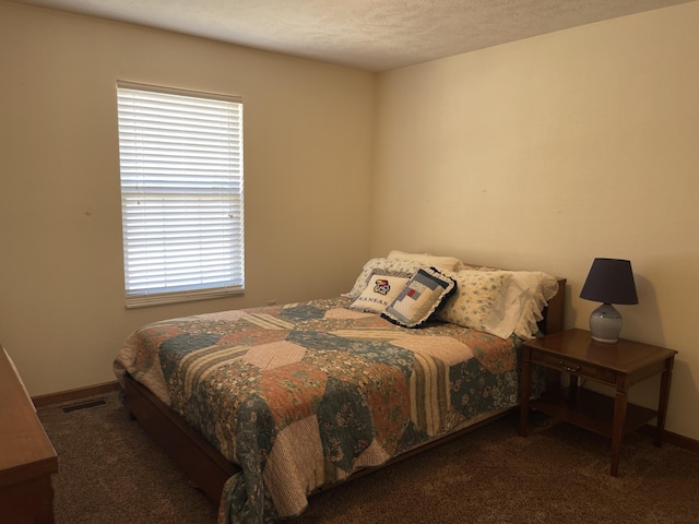 bedroom with visible vents and dark colored carpet