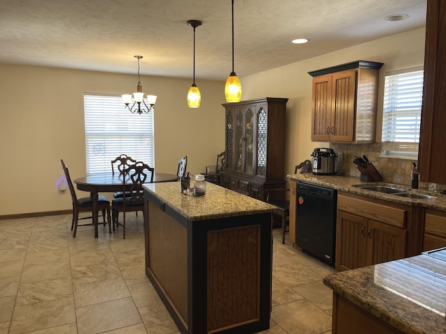 kitchen with a sink, black dishwasher, hanging light fixtures, a center island, and tasteful backsplash