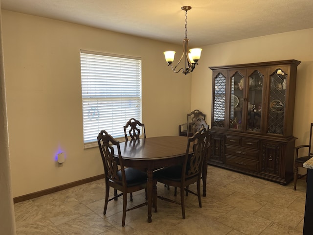 dining room with baseboards and a notable chandelier