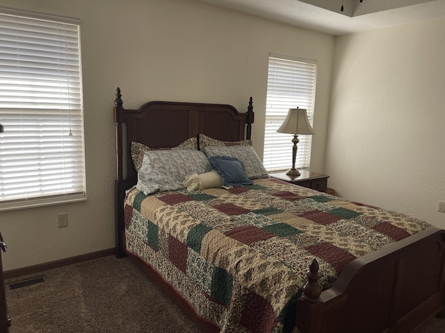 carpeted bedroom featuring visible vents and baseboards