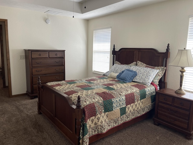 bedroom with dark colored carpet and visible vents