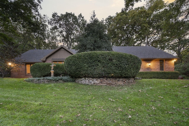 view of front of house featuring brick siding and a front yard