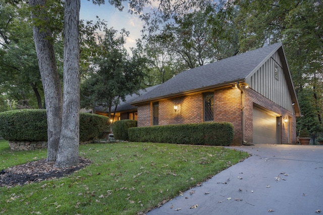 exterior space with brick siding, a lawn, an attached garage, board and batten siding, and driveway