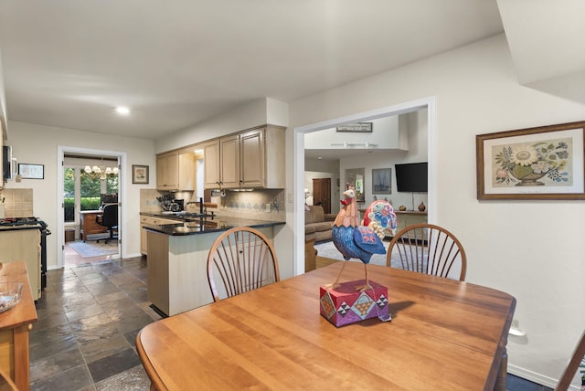 dining space featuring stone tile floors, baseboards, and a notable chandelier