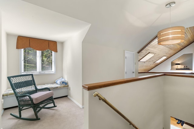 sitting room with light carpet, lofted ceiling, an upstairs landing, and baseboards