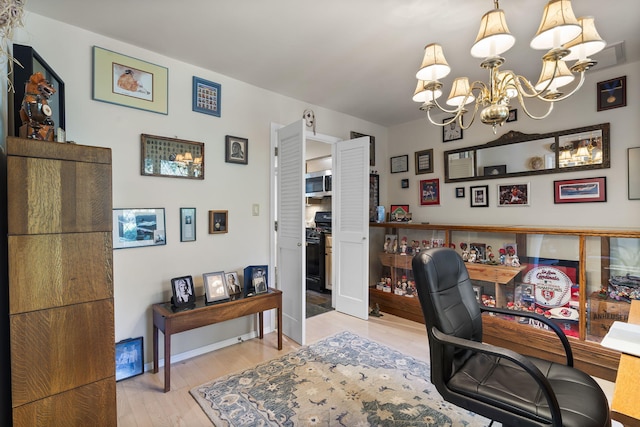 office space featuring baseboards, a notable chandelier, and light wood finished floors