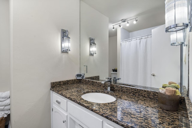 full bathroom with vanity and track lighting