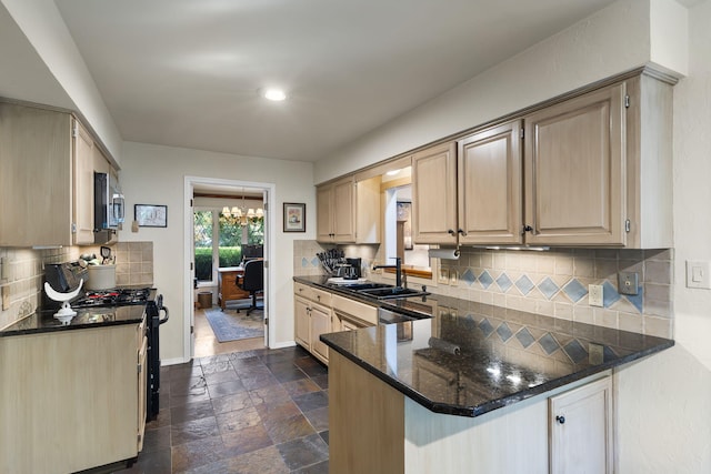 kitchen with light brown cabinets, a peninsula, a sink, stainless steel microwave, and stone tile flooring