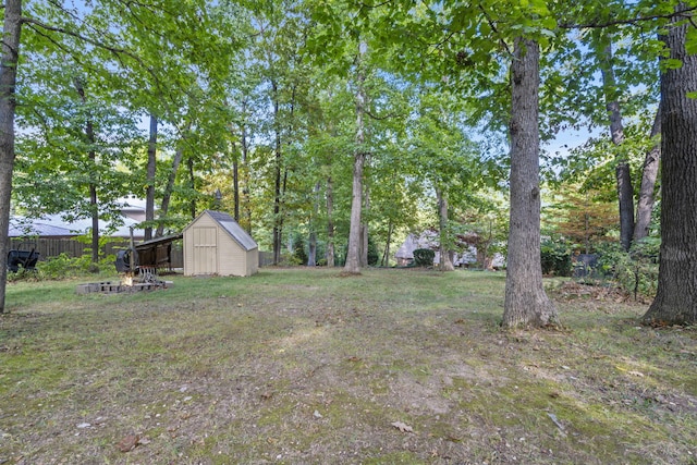 view of yard featuring a shed, fence, and an outbuilding